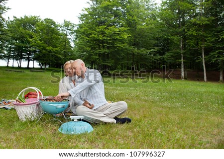 http://thumb10.shutterstock.com/display_pic_with_logo/102/107996327/stock-photo-mature-man-with-woman-cooking-food-on-a-portable-barbecue-at-an-outdoor-picnic-in-forest-park-107996327.jpg