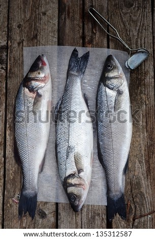 Про стоки fresh, raw sea bass on the catching board - stock photo