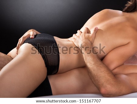 Close-up of couple having sex isolated on colored background - stock photo