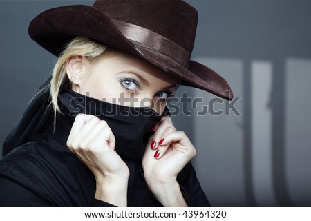 stock-photo-criminal-woman-in-the-black-coat-and-brown-hat-indoors-with-dark-shadows-43964320.jpg
