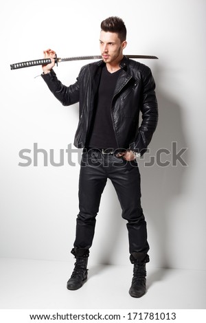 Young man holding a samurai sword. - stock photo