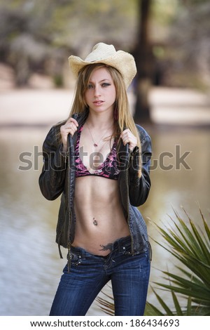 Young cowgirl wearing cowboy hat and jeans with unzipped ...