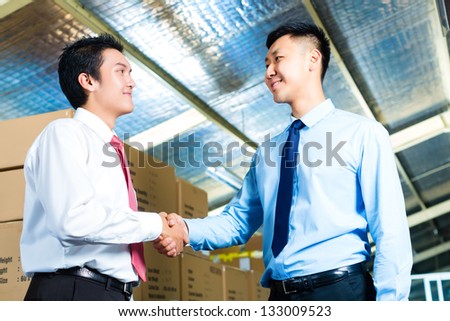  - stock-photo-manager-owner-or-businessmen-in-a-warehouse-of-a-forwarding-agency-or-a-factory-shake-hands-133009523