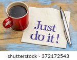 Small photo of Just do it motivational advice on napkin with a cup of coffee. Motivation concept.