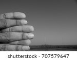 Small photo of Fingers of a male framed and photographed in such a way that at first glance looks like a stack of rocks piled up on a beach. This is a conceptual and abstract shot based principles of photography.