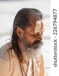 Small photo of GANGOTRI, INDIA - MAY 23rd - A Hindu priest sits in the temple courtyard to read Vedic scriptures in Gangotri on 23rd May 2013.