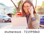 stock-photo-smiling-woman-sitting-outdoors-talking-on-mobile-phone-making-online-payment-on-her-tablet-computer-721595863.jpg