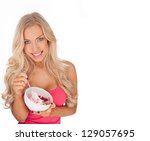 Attractive blonde Caucasian fit young woman eating ice cream from a ceramic bowl - stock photo