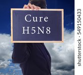 Small photo of A women holding a chalk board with word " CURE H5N8 " isolated in a background of blue sky. H5N8 is a subtype of the Influenza A virus.