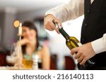 Small photo of Waiter uncorking a wine bottle in a restaurant