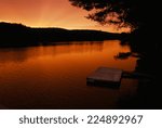 swimming dock at sunset in a...