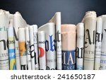 stock-photo-news-folded-newspapers-in-front-of-black-wall-241650187.jpg