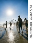 Small photo of RIO DE JANEIRO, BRAZIL - JANUARY 25, 2014: Young Brazilians play keepy uppy soccer in the sunset waves on Ipanema Beach at Posto 9, a gathering place for the sport.
