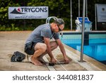 Small photo of Montreal, CANADA - May 30th, 2015. Official AIDA Freediving Pool Competition Taking place in the Parc Jean-Drapeau Olympic Pool. Staff member placing the Tape on the side of the Pool for Measurement.