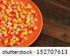 Candy corn in orange dish on rustic wood background with copy space. - stock photo