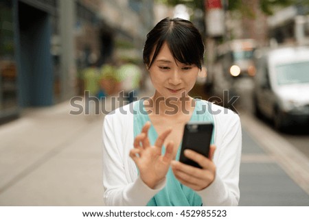 https://thumb10.shutterstock.com/display_pic_with_logo/1051921/452985523/stock-photo-young-asian-woman-walking-street-texting-cell-phone-452985523.jpg
