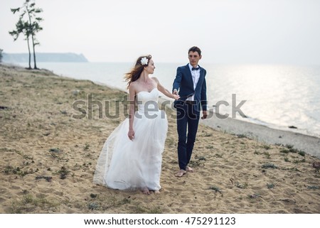 https://thumb10.shutterstock.com/display_pic_with_logo/1213778/475291123/stock-photo-happy-just-married-young-couple-celebrating-at-beautiful-beach-on-olkhon-island-475291123.jpg