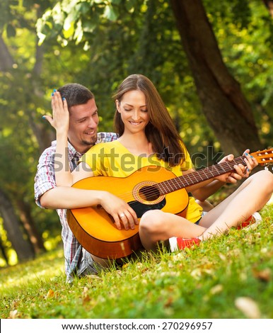 https://thumb10.shutterstock.com/display_pic_with_logo/1214444/270296957/stock-photo-young-couple-in-love-playing-acoustic-guitar-in-the-park-270296957.jpg