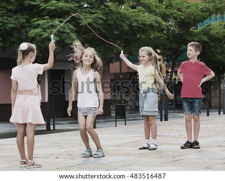 stock-photo-happy-cheerful-kids-in-school-age-playing-together-with-jumping-rope-outdoors-483516487.jpg