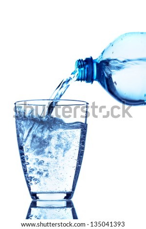 from a water bottle of water being poured into a glass - stock photo