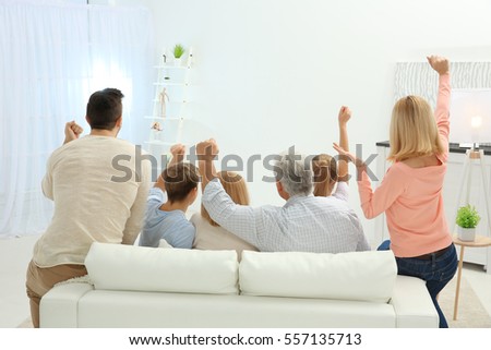 Living Room With Tv And People family watching tv while sitting on stock photo 552178765 Living Room With Tv And People family watching tv while sitting on stock photo 552178765