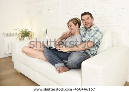 https://thumb10.shutterstock.com/display_pic_with_logo/1390159/450446167/stock-photo-young-attractive-s-couple-in-love-sitting-on-couch-happy-together-with-laptop-computer-happy-at-450446167.jpg