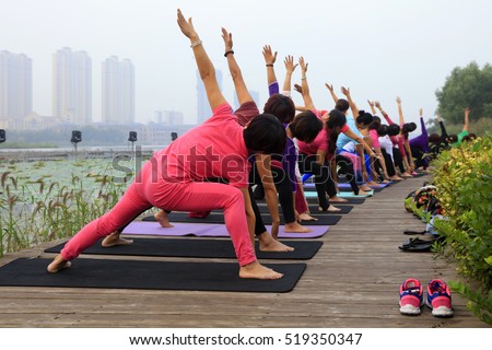 https://thumb10.shutterstock.com/display_pic_with_logo/1428302/519350347/stock-photo-woman-doing-yoga-exercise-in-the-park-china-519350347.jpg
