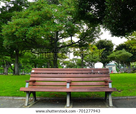 stock photo wooden chairs in the garden on tree background long wooden empty bench on green grass lawn 701277943