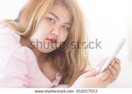 stock-photo-fat-woman-using-smart-phone-and-tablet-on-bed-person-using-digital-tablet-in-living-room-typing-652017013.jpg