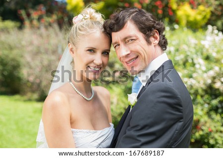stock photo pretty blonde wife hugging her new husband smiling at camera in the countryside 167689187