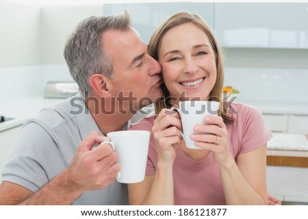 https://thumb10.shutterstock.com/display_pic_with_logo/1814639/186121877/stock-photo-close-up-of-a-man-kissing-a-happy-woman-while-having-coffee-in-the-kitchen-at-home-186121877.jpg