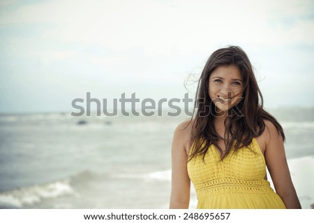 https://thumb10.shutterstock.com/display_pic_with_logo/2593219/248695657/stock-photo-a-beautiful-young-latina-woman-in-an-overcast-beach-with-a-yellow-dress-248695657.jpg