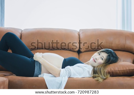 https://thumb10.shutterstock.com/display_pic_with_logo/2613007/720987283/stock-photo-beautiful-pregnant-woman-is-lying-on-sofa-in-the-living-room-happy-family-concept-720987283.jpg