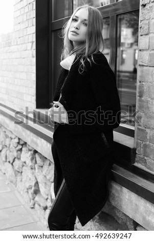 https://thumb10.shutterstock.com/display_pic_with_logo/4078816/492639247/stock-photo-black-and-white-photo-beautiful-young-blonde-woman-walking-on-the-street-dressed-in-a-black-coat-492639247.jpg