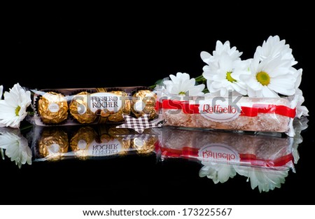 ZAGREB , CROATIA - JANUARY 24 ,2014 : chocolate candy ferrero rocher and raffaello with flowers on the table , product shot - stock photo