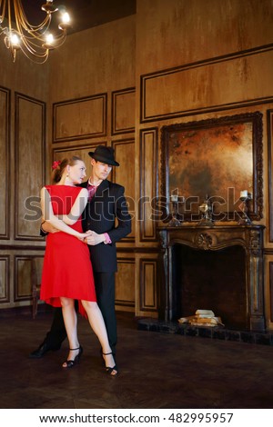 https://thumb10.shutterstock.com/display_pic_with_logo/4225/482995957/stock-photo-happy-handsome-girl-and-man-in-black-hat-dancing-tango-in-retro-room-482995957.jpg