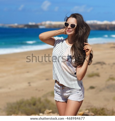 https://thumb10.shutterstock.com/display_pic_with_logo/571009/468984677/stock-photo-young-beautiful-stylish-girl-posing-at-beach-on-a-windy-day-468984677.jpg