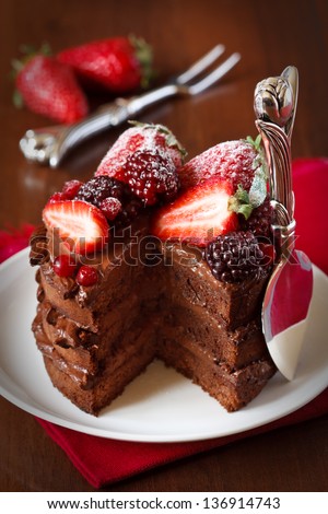 Delicious chocolate cake with cream and berries close up. - stock photo