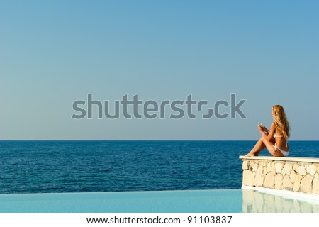 stock photo beautiful woman in white bikini sitting near infinity pool and looking to sea and horizon crete 91103837