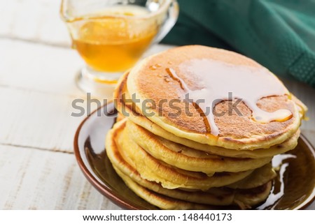 Appetizing pancakes on plate with honey/syrup on white table. Healthy ...