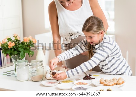 Woman Decorating Cupcakes pregnant mum her little daughter baking stock photo 483749908 Woman Decorating Cupcakes pregnant mum her little daughter baking stock photo 483749908